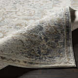 Close-up of the Beebe Luxe Machine Area Rug showing its ivory, gray, and brown traditional pattern and soft texture. Fold