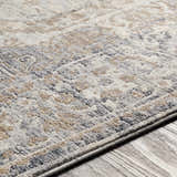 Close-up of the Beebe Luxe Machine Area Rug showing its gray, ivory, and brown traditional pattern and soft texture. Texture