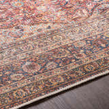 Close-up of the Belison Washable Area Rug. Traditional, farmhouse style with red, orange, and blue tones. Machine woven texture. Texture