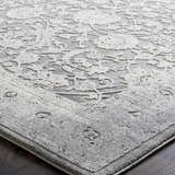 Close-up of the Benavides Gray Updated Traditional Tibetan Rug, showing its charcoal and ivory floral pattern. Texture
