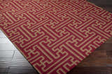 Close-up of the Bentonville Area Carpet. Brick red wool rug with a tan geometric pattern on dark wood floors. Corner