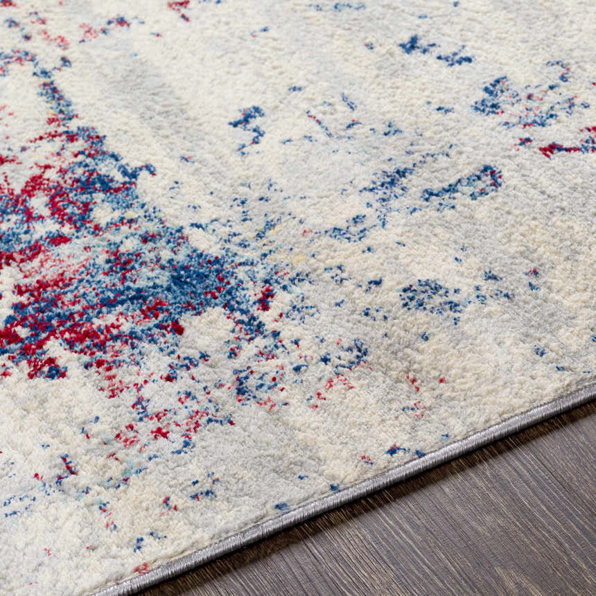Close-up of the Bergvliet Area Rug: cream rug with blue and burgundy contemporary pattern on dark wood floor. Texture