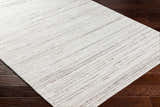 Close-up of the hand-loomed Beykoz Area Rug in cream and light beige with a subtle dark brown striped pattern. Corner