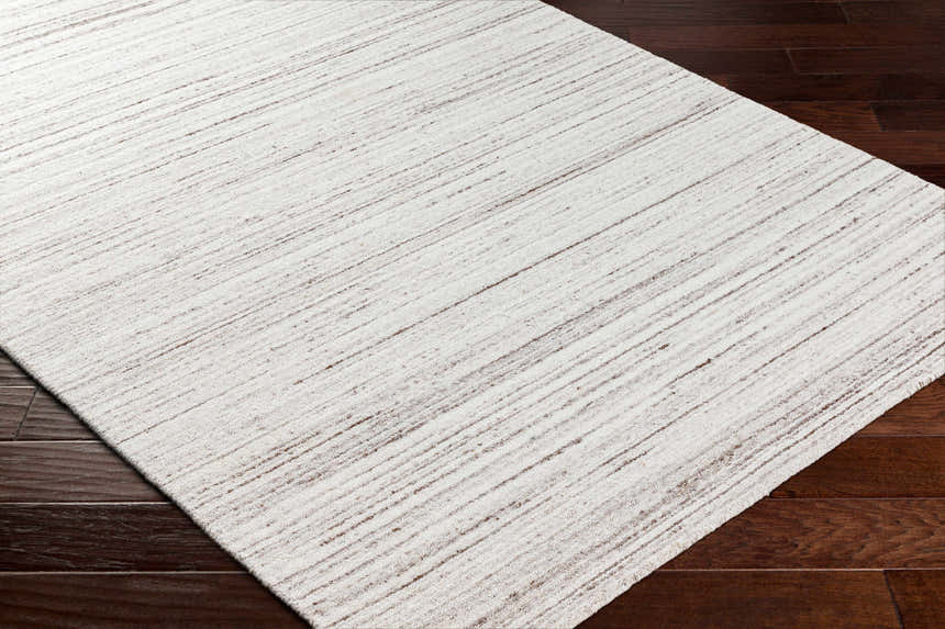 Close-up of the hand-loomed Beykoz Area Rug in cream and light beige with a subtle dark brown striped pattern. Corner
