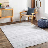 Living room with the cream and brown striped Beykoz Area Rug, wood furniture, and blue accents. Roomscene-Rectangle