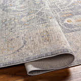 Close-up of the Binx Thick Luxe Statement Rug showing its brown, charcoal, and gray traditional pattern and soft, plush texture. Fold