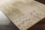 Close-up of Bissell Area Carpet. Hand-knotted wool rug in dark brown, light brown, and off-white with a contemporary leaf pattern. Corner