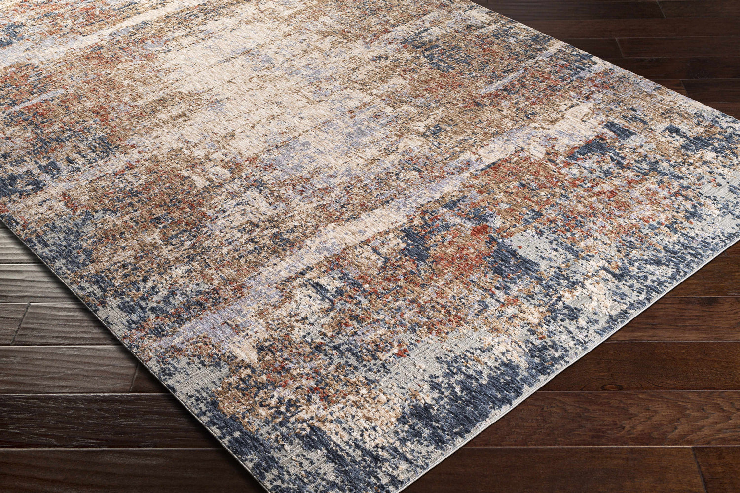 Close-up of Bonaventure Area Rug on dark wood floor. Charcoal, red, gray, navy, and rust contemporary design. Corner