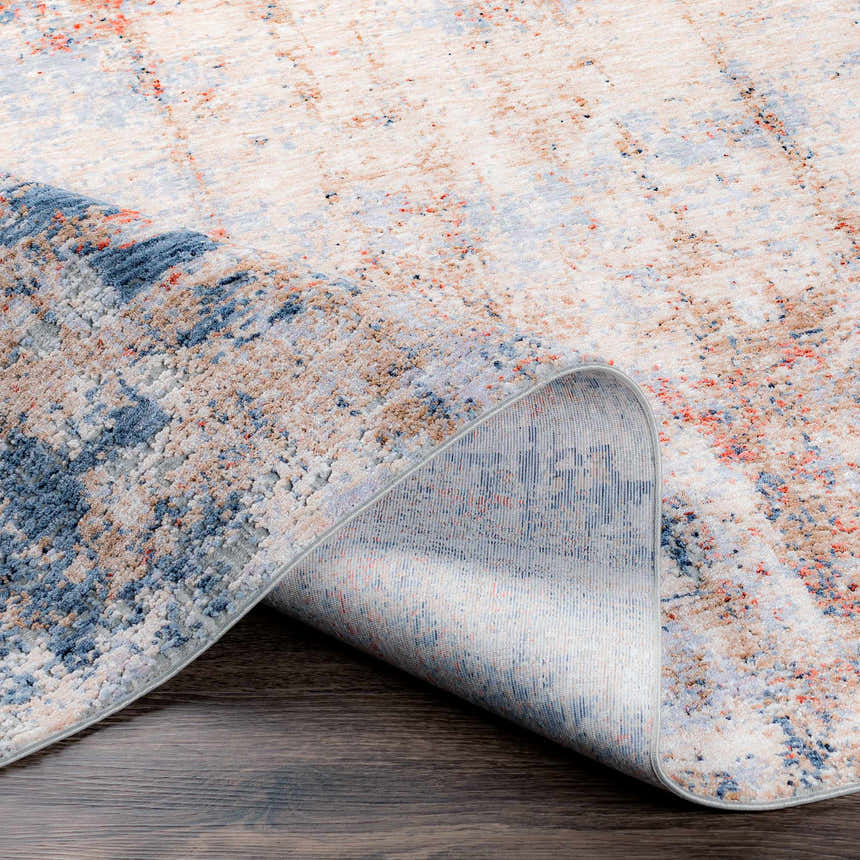 Close up of the Bonaventure Area Rug showing charcoal, red, gray, and navy abstract pattern and machine woven texture. Fold