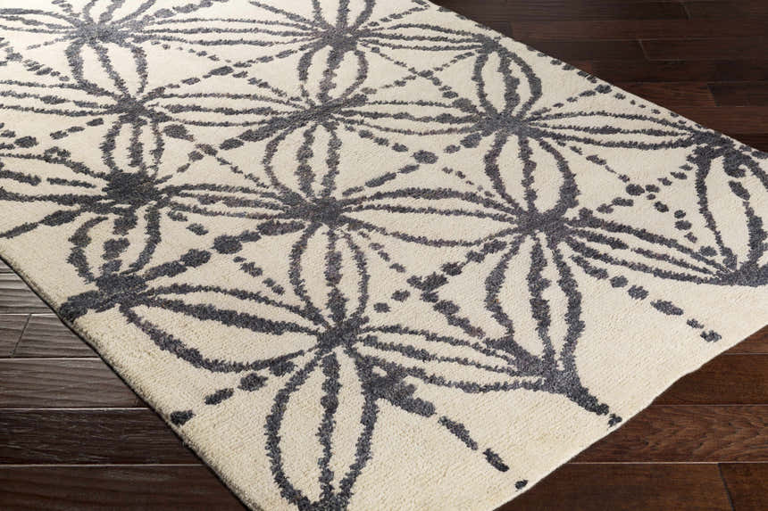 Close-up of Bonnyman Jute Carpet. Hand-woven rug with black floral pattern on ivory. Contemporary style. Corner