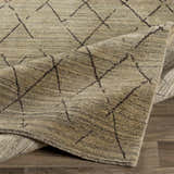 Close-up of the Bonogin Area Rug showing its tan and olive colors and dark brown geometric diamond pattern. Fold