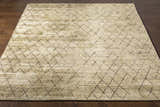 Close-up of the Bonogin Area Rug showing its olive and tan colors and dark brown geometric diamond pattern. Front
