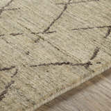 Close-up of the hand-loomed Bonogin Area Rug showing its olive and tan colors and dark brown geometric pattern. Texture