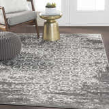 Living room scene with gray chair, pouf, and gold table on charcoal and white Bowden Carpet. Roomscene-Rectangle