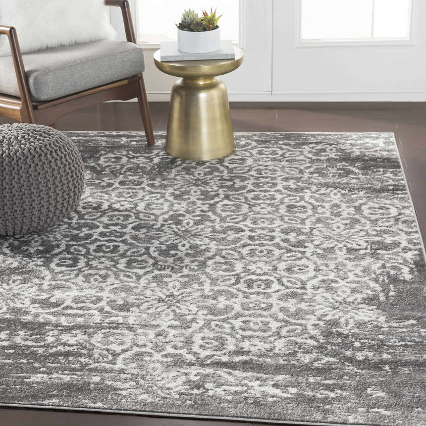 Living room scene with gray chair, pouf, and gold table on charcoal and white Bowden Carpet. Roomscene-Rectangle