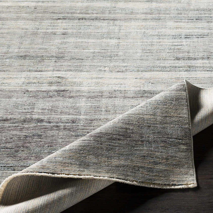 Braxton Carved Statement Area Rug close-up. Abstract design in gray, ivory, and charcoal. Machine woven texture. Fold