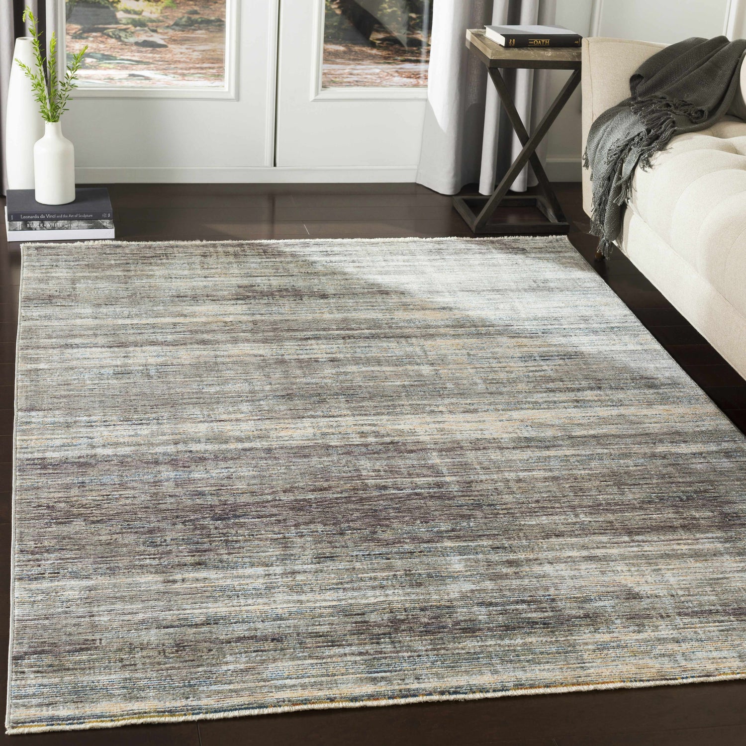 Living room scene with Braxton Carved Statement Area Rug in blue, gray, and ivory tones on dark wood floors. Roomscene-Rectangle
