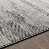 Close up of the Braxton Carved Statement Area Rug showing its carved texture and colors of gray, ivory and charcoal. Texture
