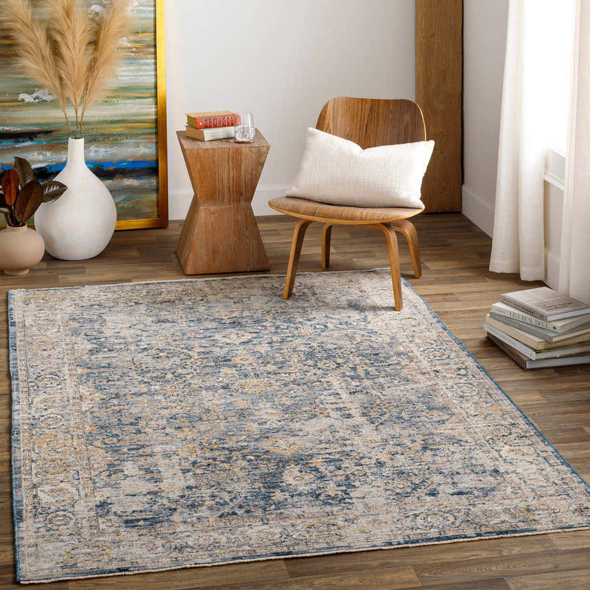 Living room scene with a blue and beige Barcelona Luxe Performance Rug, wood chair, and modern decor. Roomscene-Rectangle