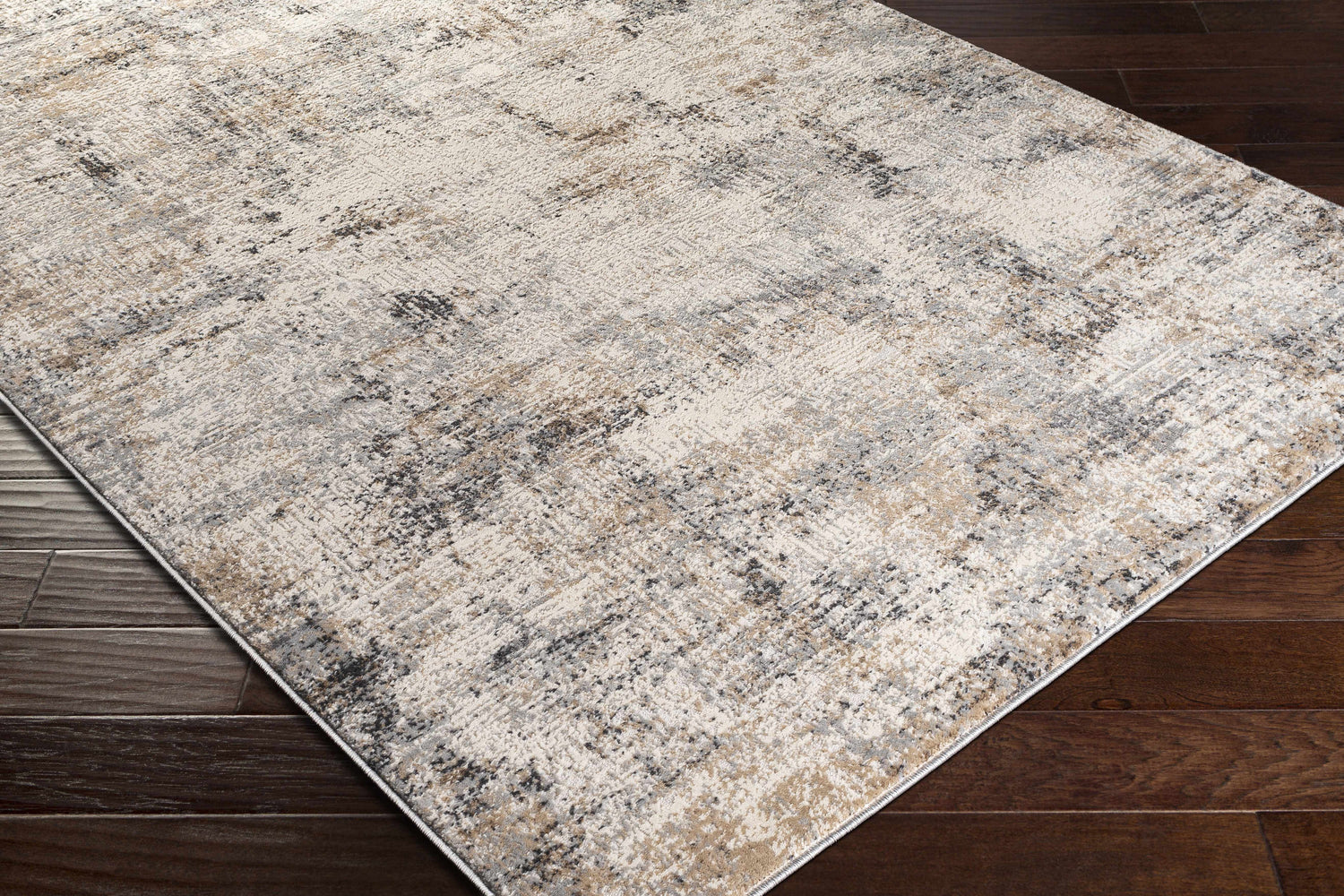 Close-up of the Braddyville Area Rug, a contemporary rug in cream, gray, black, and brown, on a dark wood floor. Corner