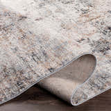 Close-up of the Braddyville Area Rug showing its contemporary design, and colors: cream, gray, tan, brown, and black. Fold