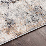 Close-up of the Braddyville Area Rug showing its contemporary black, brown, cream and gray abstract design and soft texture. Texture