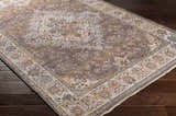 Close-up of the Bourget Area Carpet. Bohemian style rug in brick red, cream, and blue on a dark wood floor. Corner