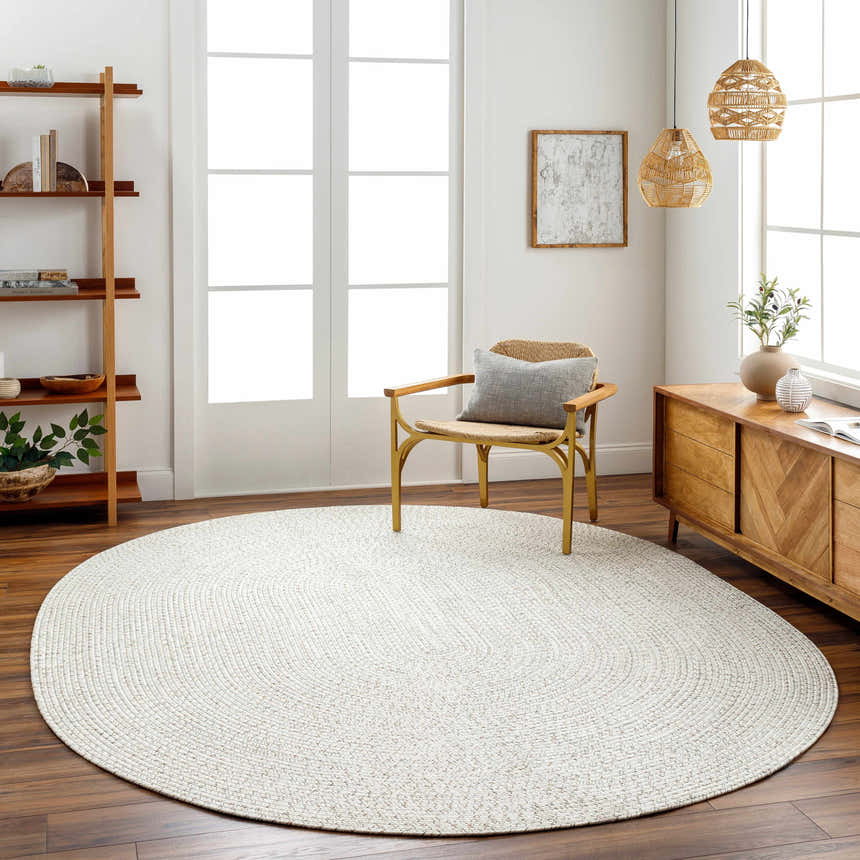 Living room with a Beige Braided Faux Jute Rug, wood floors, woven chair, and natural wood accents. Roomscene-Oval