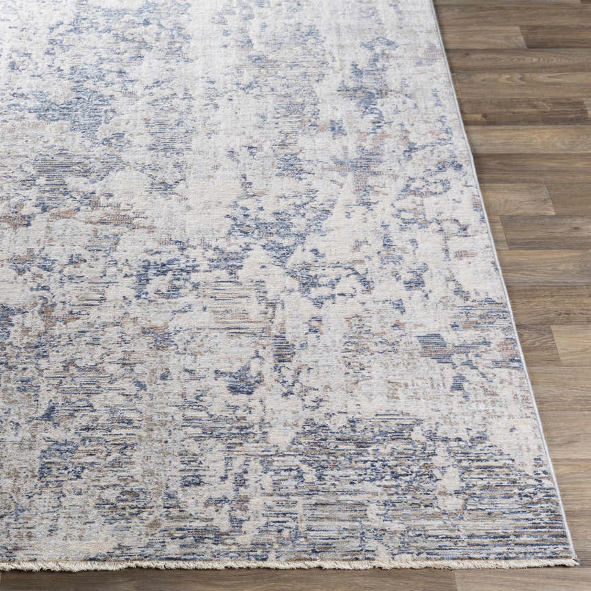 Close-up of the Broxbourne Area Rug. Contemporary design in blush, brown, cream, and navy on a wood floor. Front