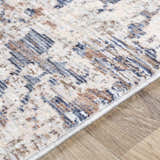 Close-up of the Broxbourne Area Rug showing a contemporary design in blush, brown, cream, and navy colors. Texture
