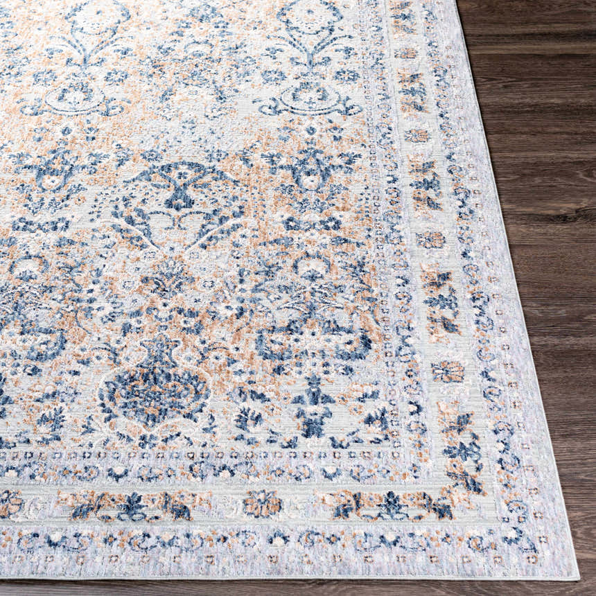 Close-up of the Barrie Area Carpet. Machine-woven polyester rug with a traditional blue, cream, and brown floral pattern. Front