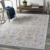 Farmhouse living room scene with a Barrie Area Carpet in beige, blue, and gray tones on dark wood floors. Metal chair and shelf. Roomscene-Rectangle