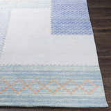 Close-up of the Bishopstoke Carpet, a hand-woven rug with blue, cream, and peach tones. Features a geometric pattern. Front
