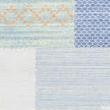 Close-up of Bishopstoke Carpet, a hand woven rug in blue, cream, and peach with geometric patterns. Swatch