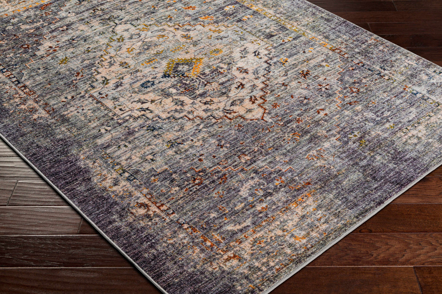 Close-up of Basiad Washable Area Rug showing traditional oriental design, blush, gray, purple, and mustard colors. Corner
