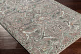 Close-up of the hand-knotted Bugasan Area Rug. Plum, tan, teal, and gray tones create a traditional, bohemian pattern. Corner