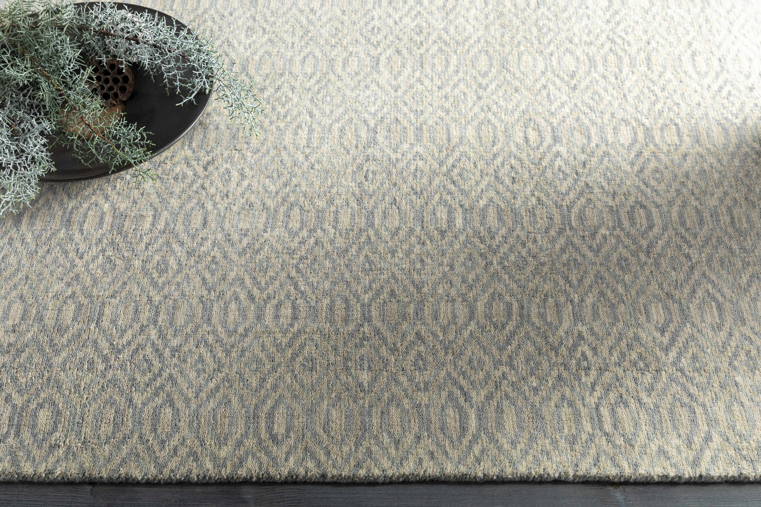 Close up of the Bumpass Area Rug. Light sage and medium gray wool rug with a geometric diamond pattern. Styleshot