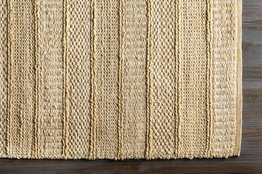 Close-up of the hand woven Bywong Area Rug. Beige and off-white jute rug with a farmhouse, transitional style. Corner