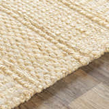 Close-up of the hand-woven Bywong Area Rug. Beige and off-white jute rug with a textured, farmhouse style design. Texture