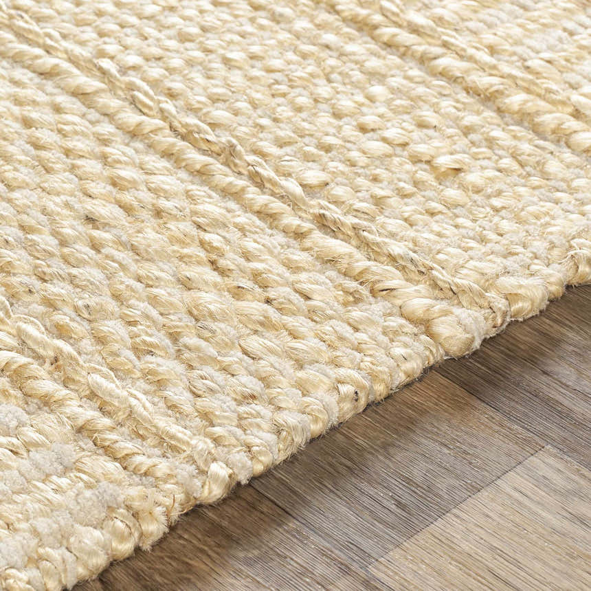 Close-up of the hand-woven Bywong Area Rug. Beige and off-white jute rug with a textured, farmhouse style design. Texture
