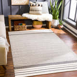 Living room scene with beige sofa and Calumpang Area Carpet. Hand woven cotton rug in beige and black with striped Southwestern design. Roomscene-Rectangle