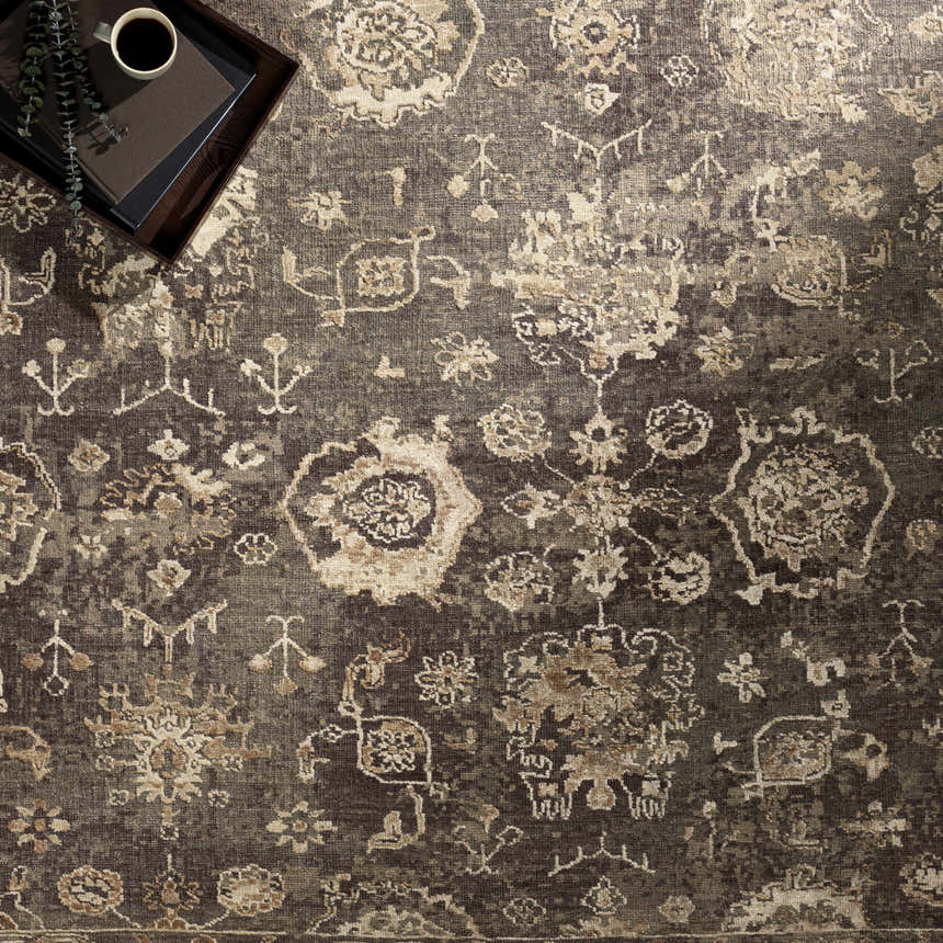 Close-up of the Cantley Handmade Wool Area Rug. Charcoal rug with cream, beige, and brown traditional floral pattern. Styleshot