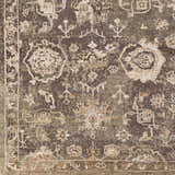 Close-up of Cantley Handmade Wool Area Rug showing charcoal, cream, and brown floral and geometric pattern. Texture