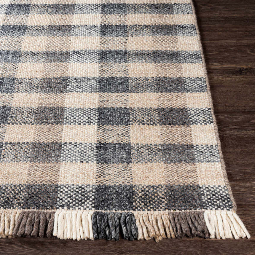 Close-up of the hand-woven Chilliwack Gray Plaid Wool Rug showing charcoal, cream, and gray tones with fringed edge. Front