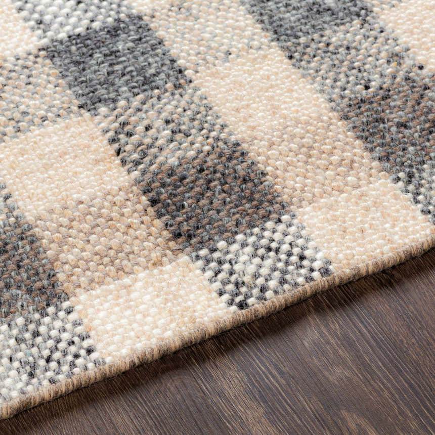 Close-up of the Chilliwack Gray Plaid Wool Rug showing charcoal, cream, gray, and tan tones and hand-woven texture. Texture