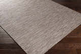 Close-up of the Coolville Brown Flatweave Area Carpet showing its woven texture and neutral brown, cream, and tan colors. Corner