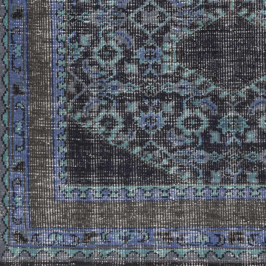 Close up of the Chesham Clearance Rug showing its dark blue, teal, and charcoal traditional pattern. Swatch