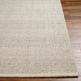 Close-up of the Cinco Luxe Rug showing its bone and gray geometric pattern and soft, textured pile on a wood floor. Front