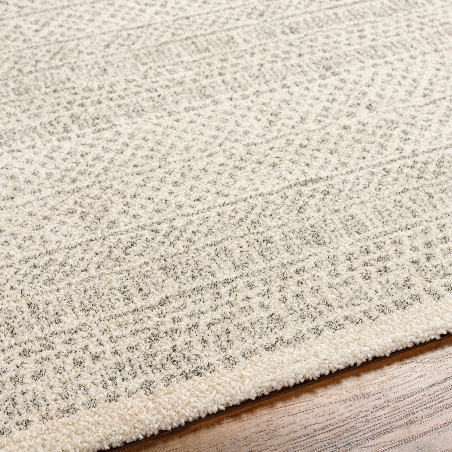 Close-up of the Cinco Luxe Rug showing its bone and gray contemporary pattern and soft, textured weave. Texture