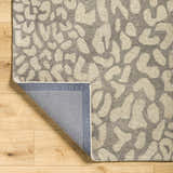 Close-up of the Circa Leopard Print Area Rug showing the beige and gray wool texture and backing. Fold